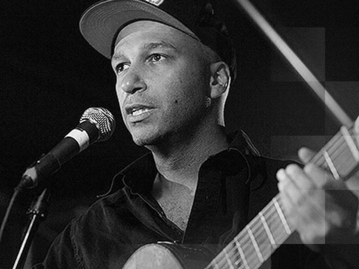 Tom Morello singing and playing the guitar.