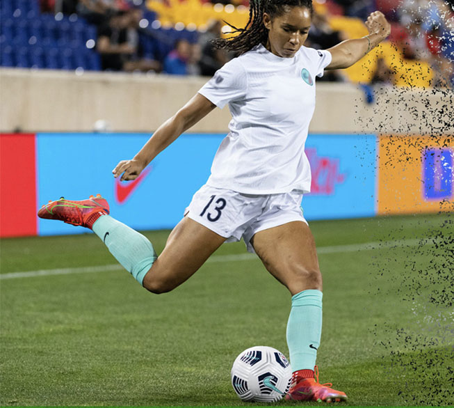 female athlete kicking a soccerball