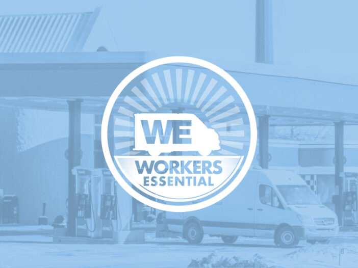 Workers Essential Logo in front of Amazon delivery trucks at a gas station.